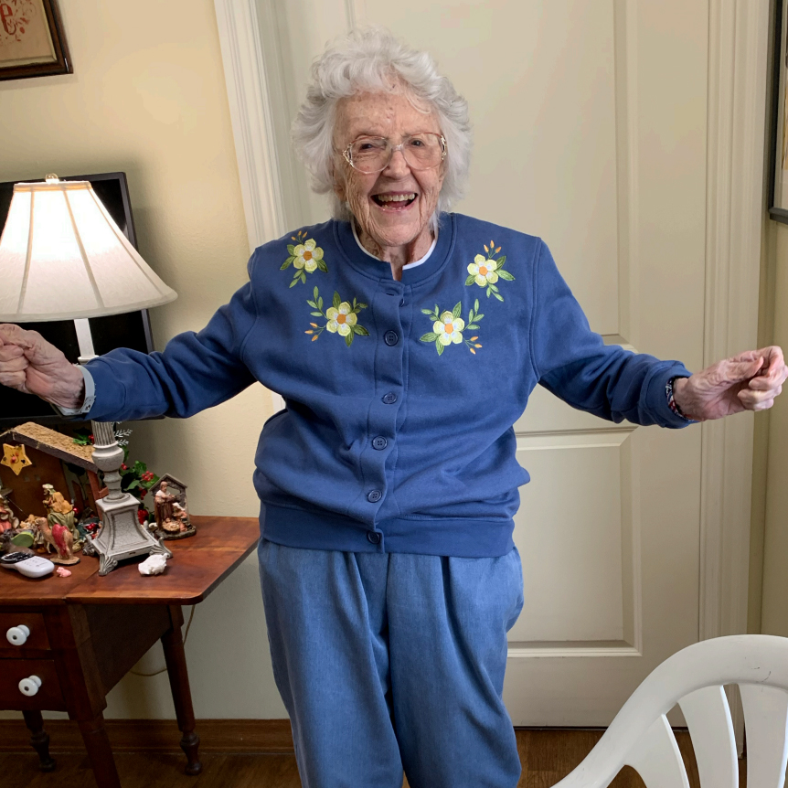 A current photo shows Mary standing wearing a blue sweatshirt and pants. She looks comfortable and relaxed and might be up to a dance.