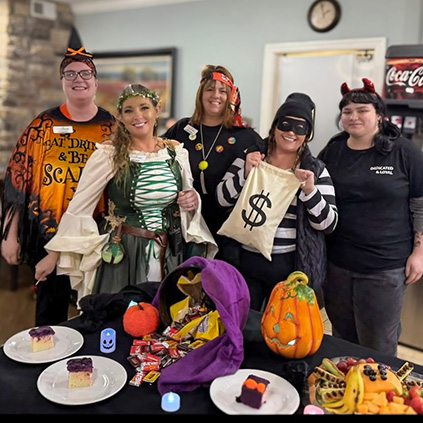 Team members dressed in fun Halloween costumes enjoy a party.
