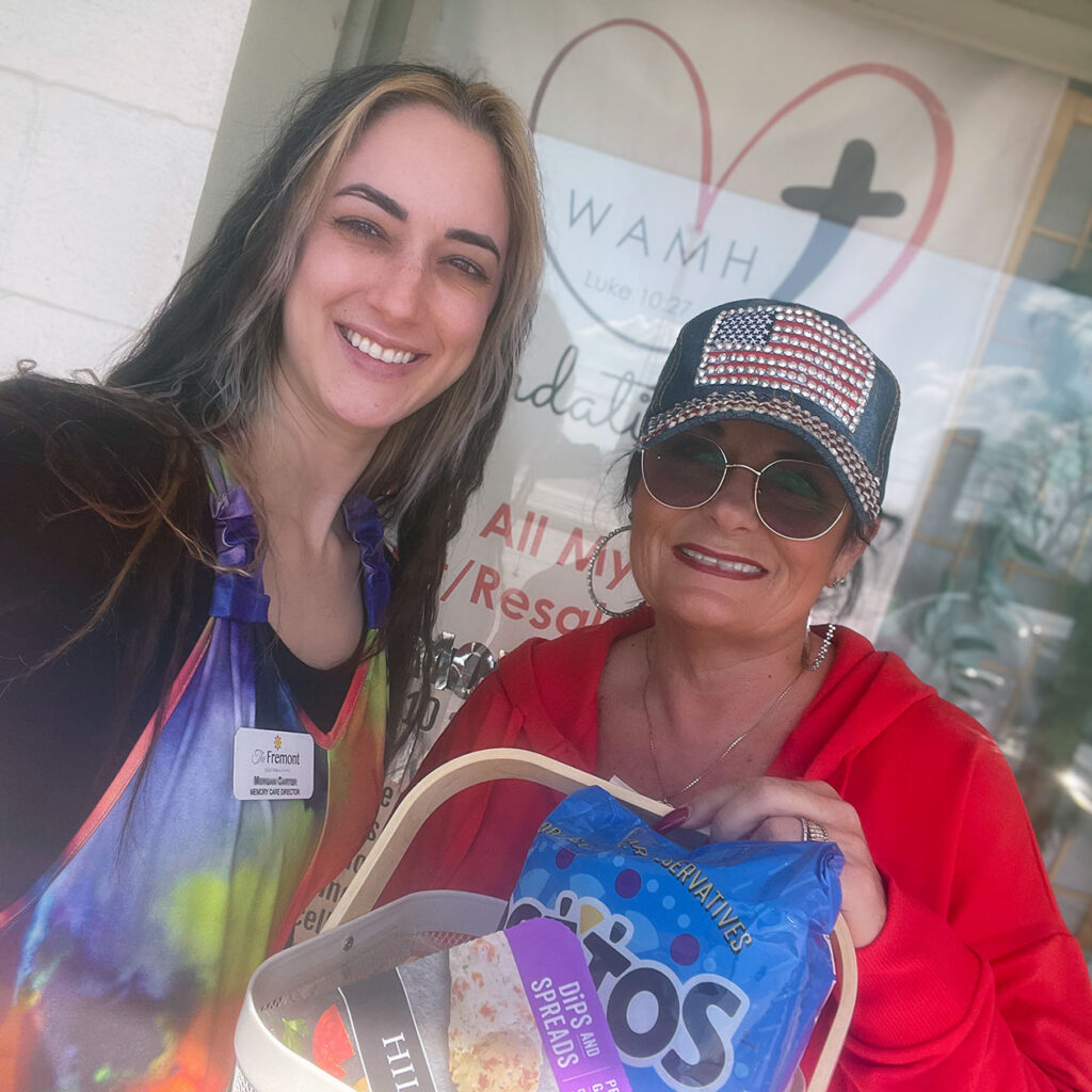 A woman from The Fremont Senior Living presents a gift basket to a local business owner.